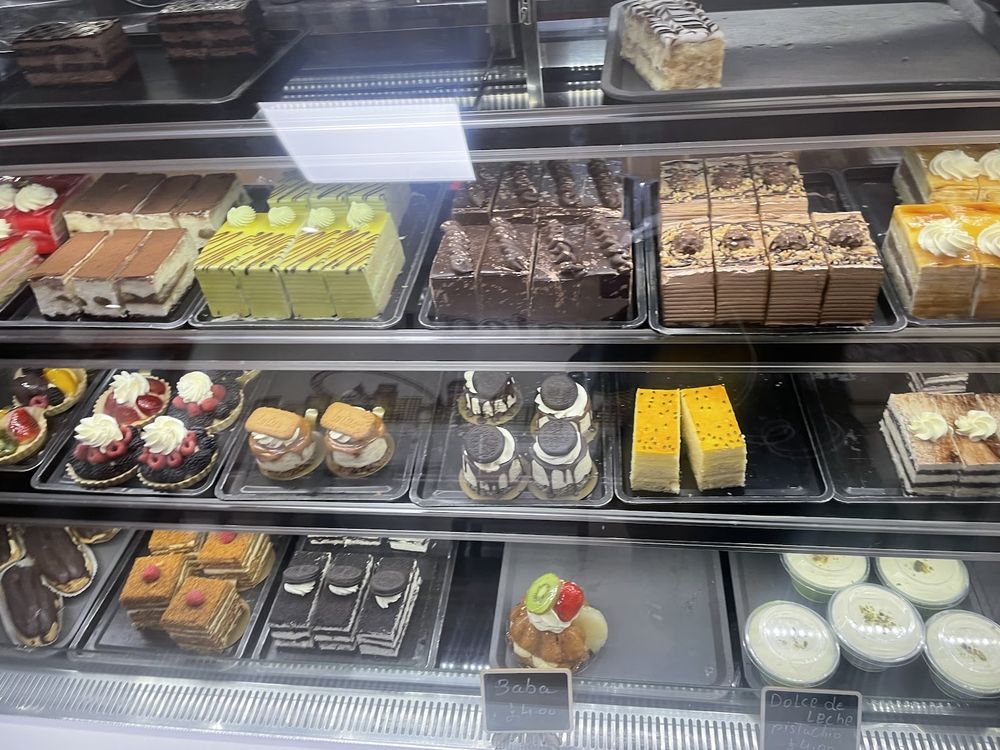 The long patisserie counter packed with rows of cakes, slices, tarts and cheesecakes